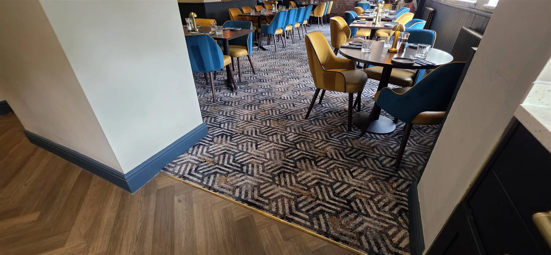 Brass trim closing the transition between herringbone LVT and the Calderdale carpet at The Talbot, Belbroughton