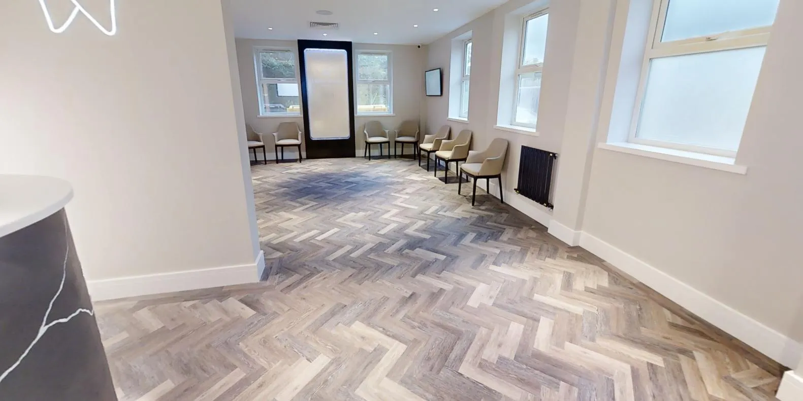 Herringbone LVT through the reception at Abbey House Dental, around the curved reception desk